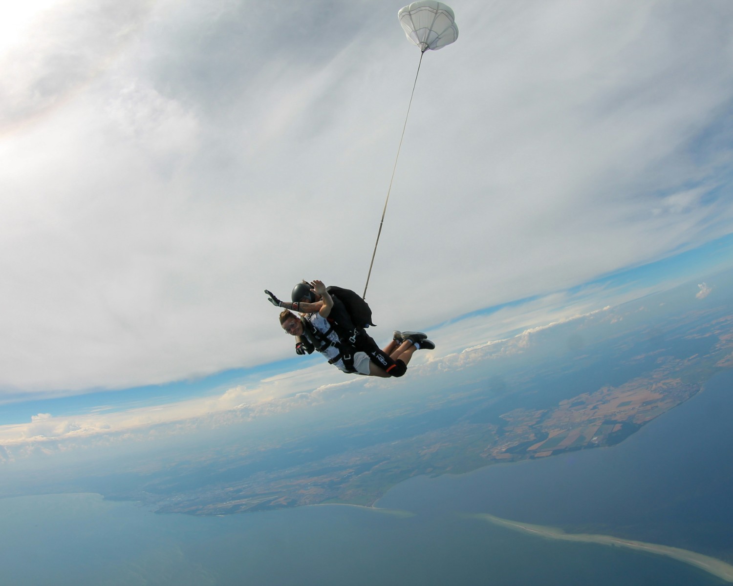 Tandem paraglider soaring over Kangra Valley with Dhauladhar range backdrop