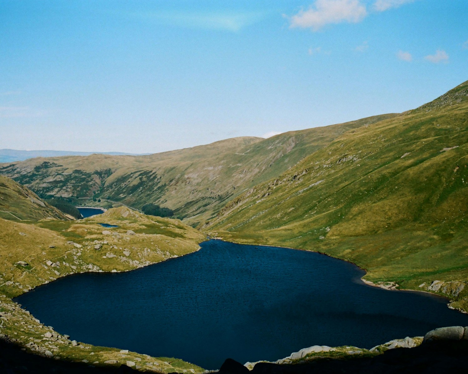 Windermere lake with surrounding mountain peaks and sailing boats