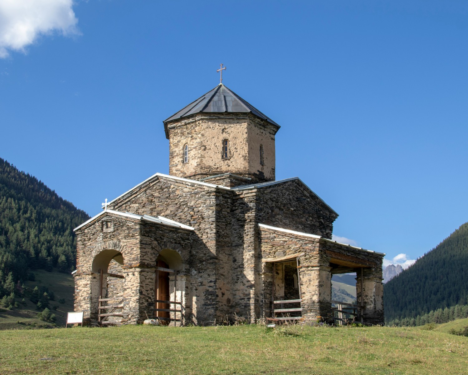 The church surrounded by alpine meadows and snow-capped peaks
